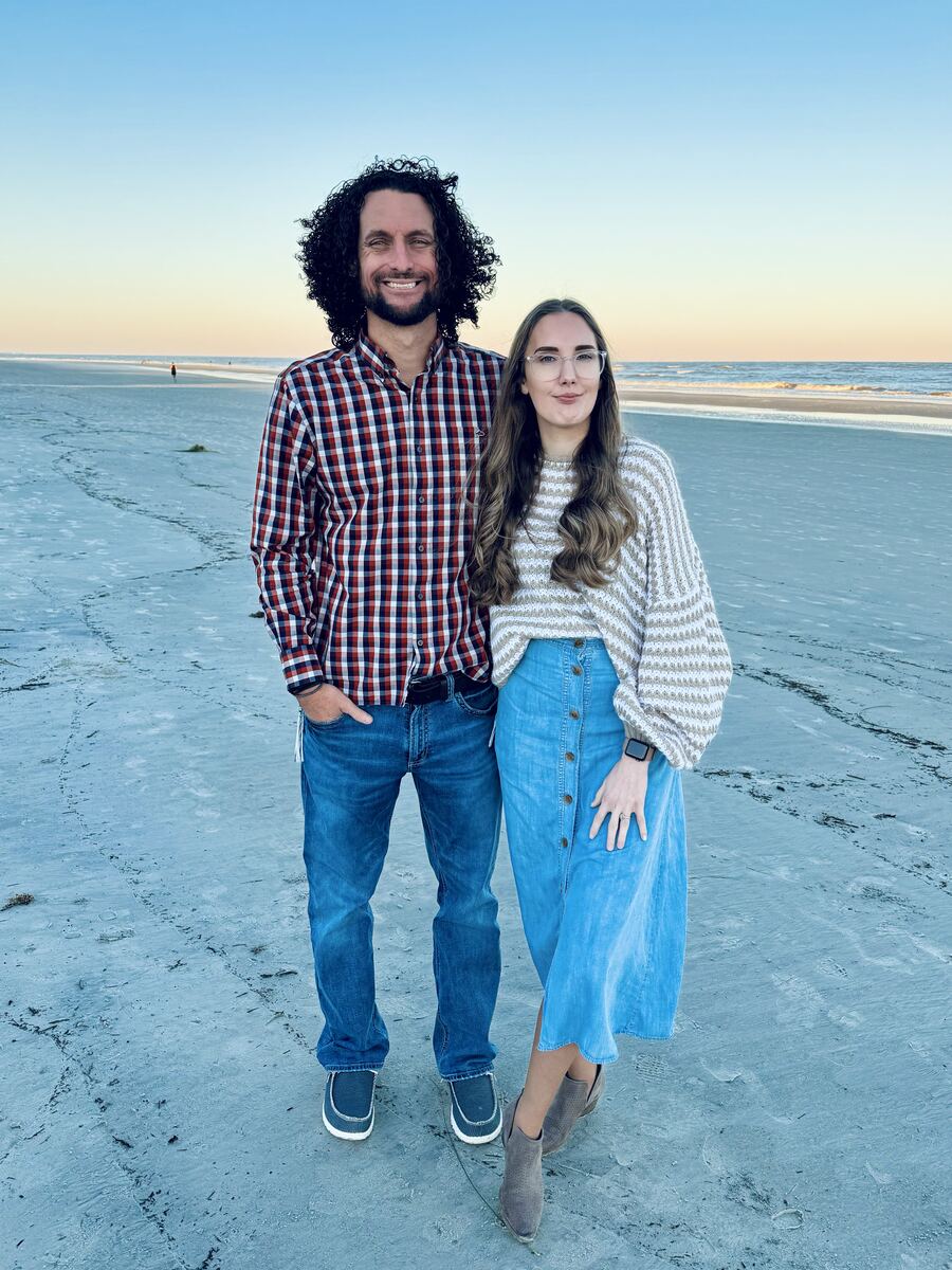 Branden Dasher and his wife, standing together on a beach at dusk